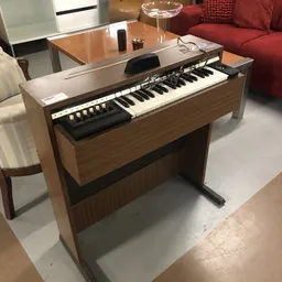 Houten elektronisch orgel met toetsenbord en bedieningspaneel in kringloopwinkel