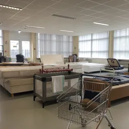 Winkelvloer met uitgestalde meubels, matrassen, beddengoed en huishoudartikelen in een kringloopwinkel