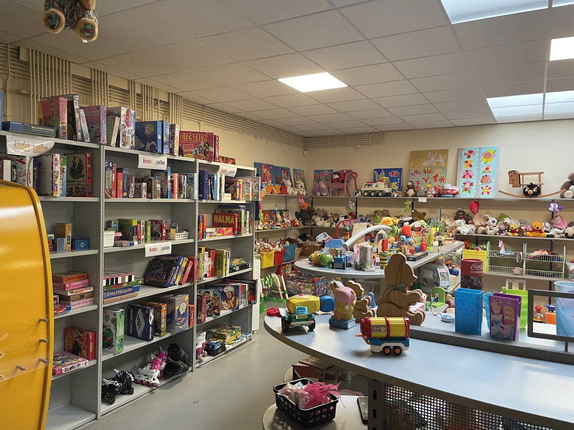 Kinderkamer-afdeling met boeken, speelgoed en decoraties op tafels en stellingen