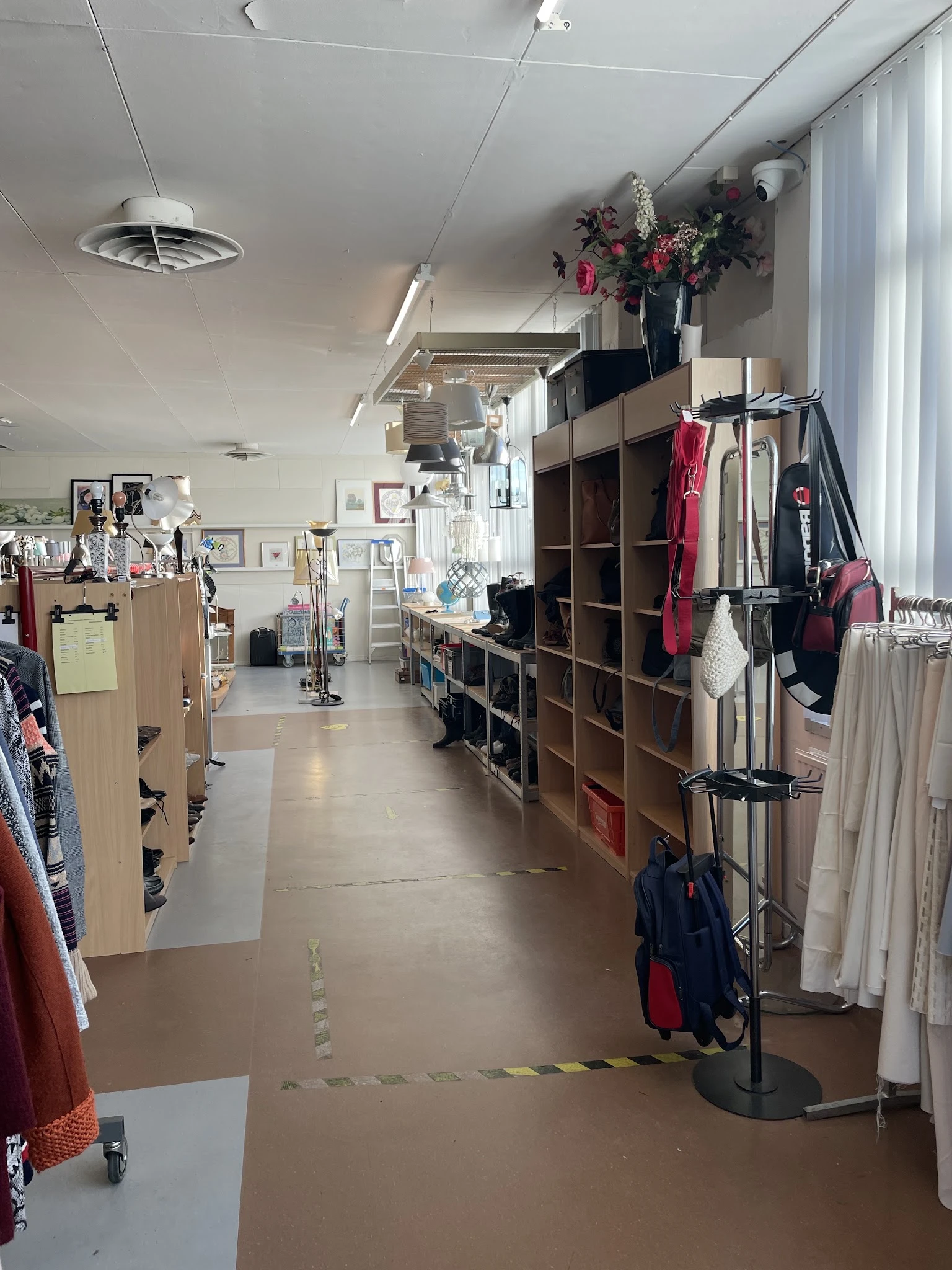 Winkelinterieur met kledingrekken, stellingen met textiel en diverse tweedehands artikelen