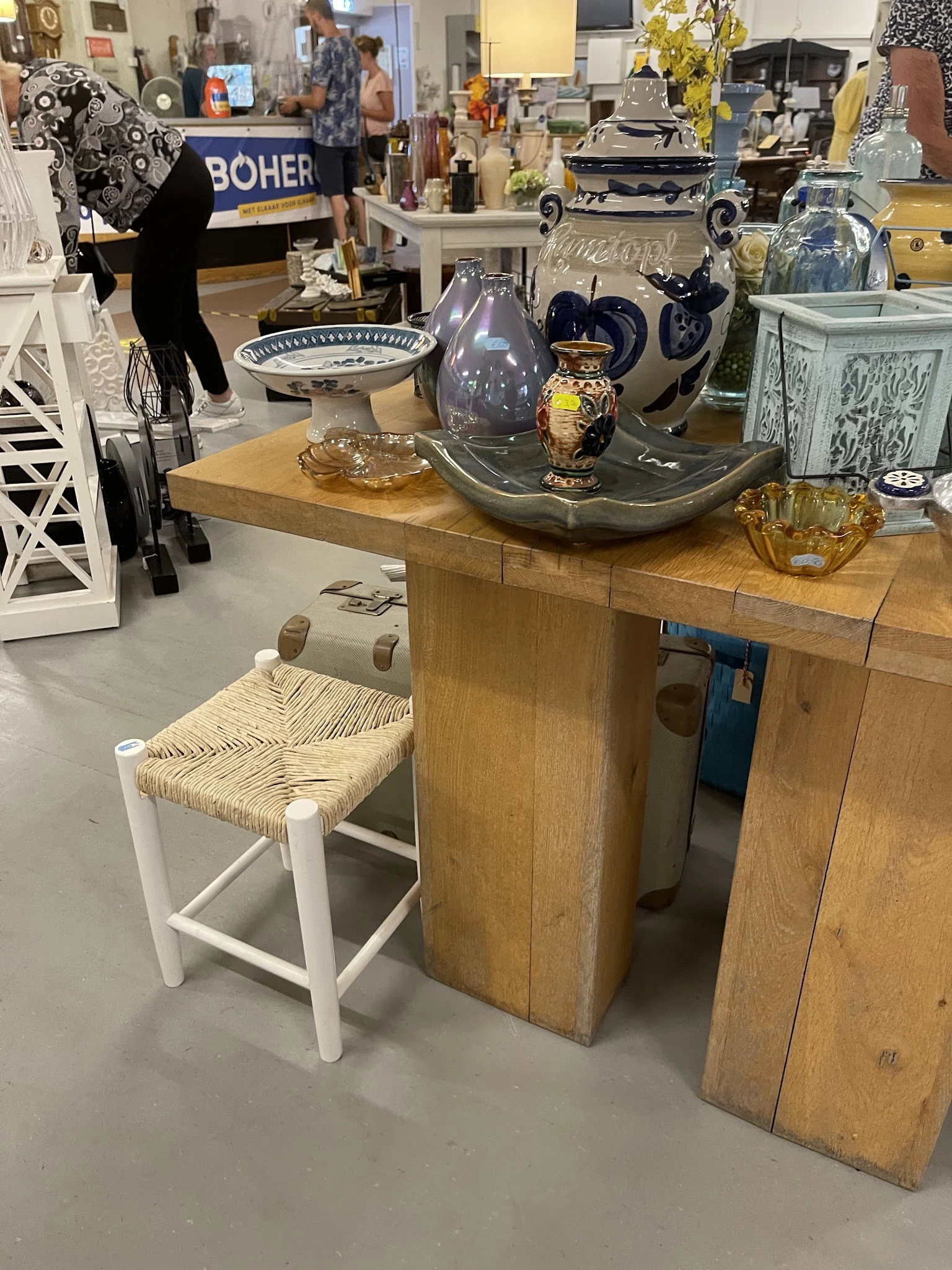 Houten tafels en stoelen met decoratieve items zoals serviesgoed en vazen op het blad