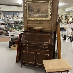 Antieke houten commode met goud decoratief inlay en fraaie handvatten, in kringloopwinkel
