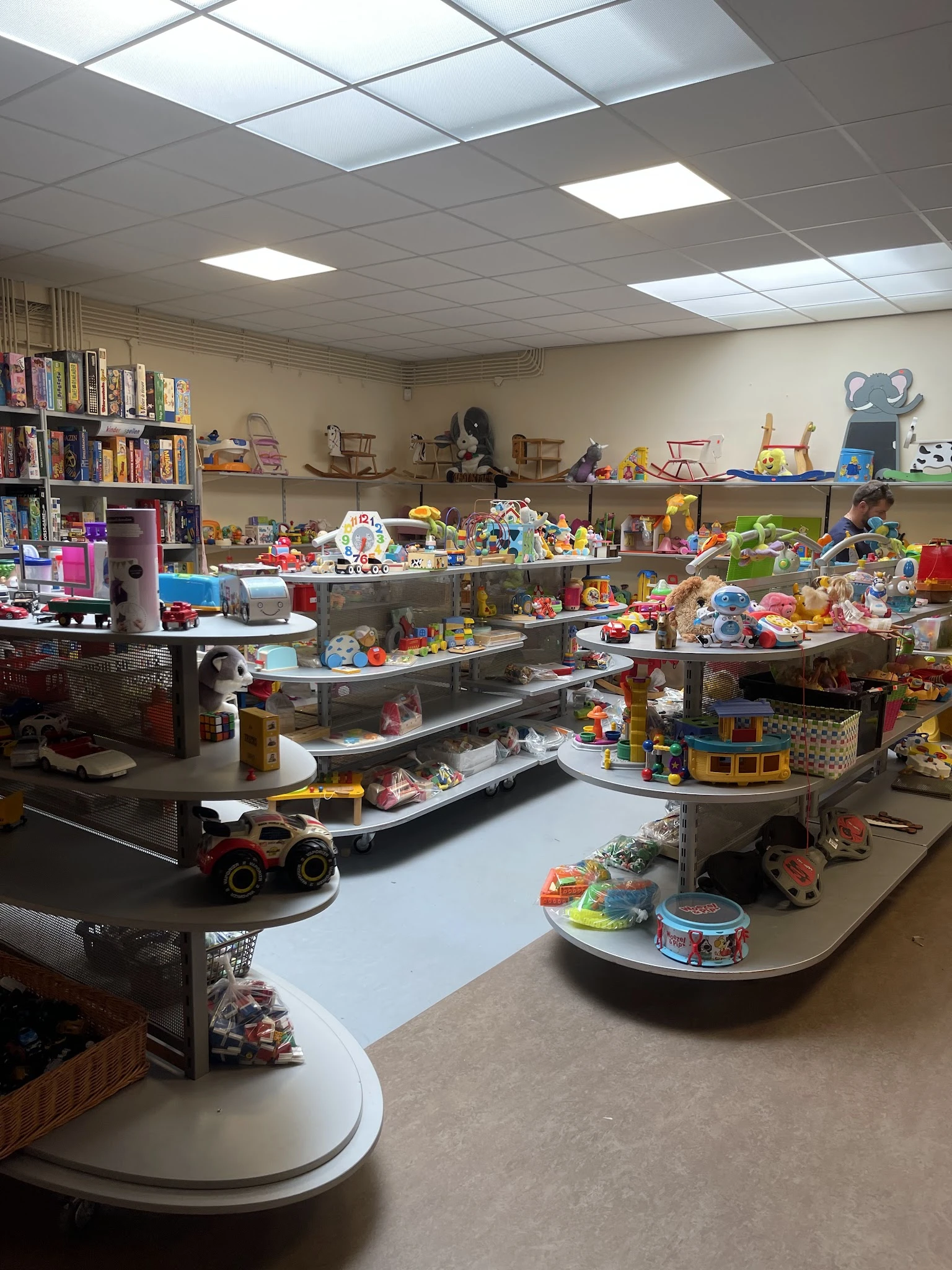 Kinderspeelgoed uitgestald op tafels en stellingen in de kringloopwinkel