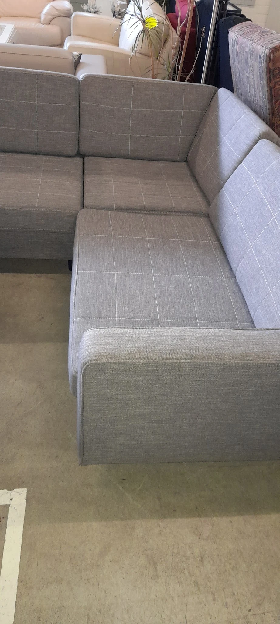 Close-up van een grijze gestoffeerde bank of zetel met quilting patroon