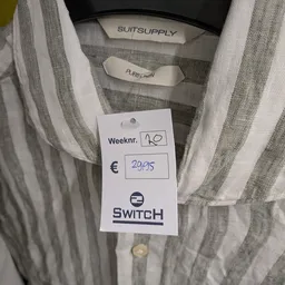 Prijskaartje van SWITCH met weeknummer en euro-bedrag op een gestreept kledingstuk