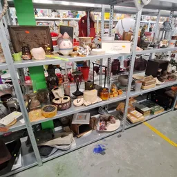 Metalen stellingkast met diverse tweedehands huishoudartikelen, decoratie en serviesgoed
