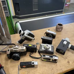 Verzameling vintage camera's en filmapparatuur op houten tafel