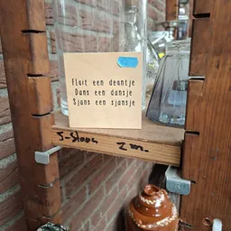 Houten deurtje met gedicht op papier geplakt, handgeschreven aantekening onderaan