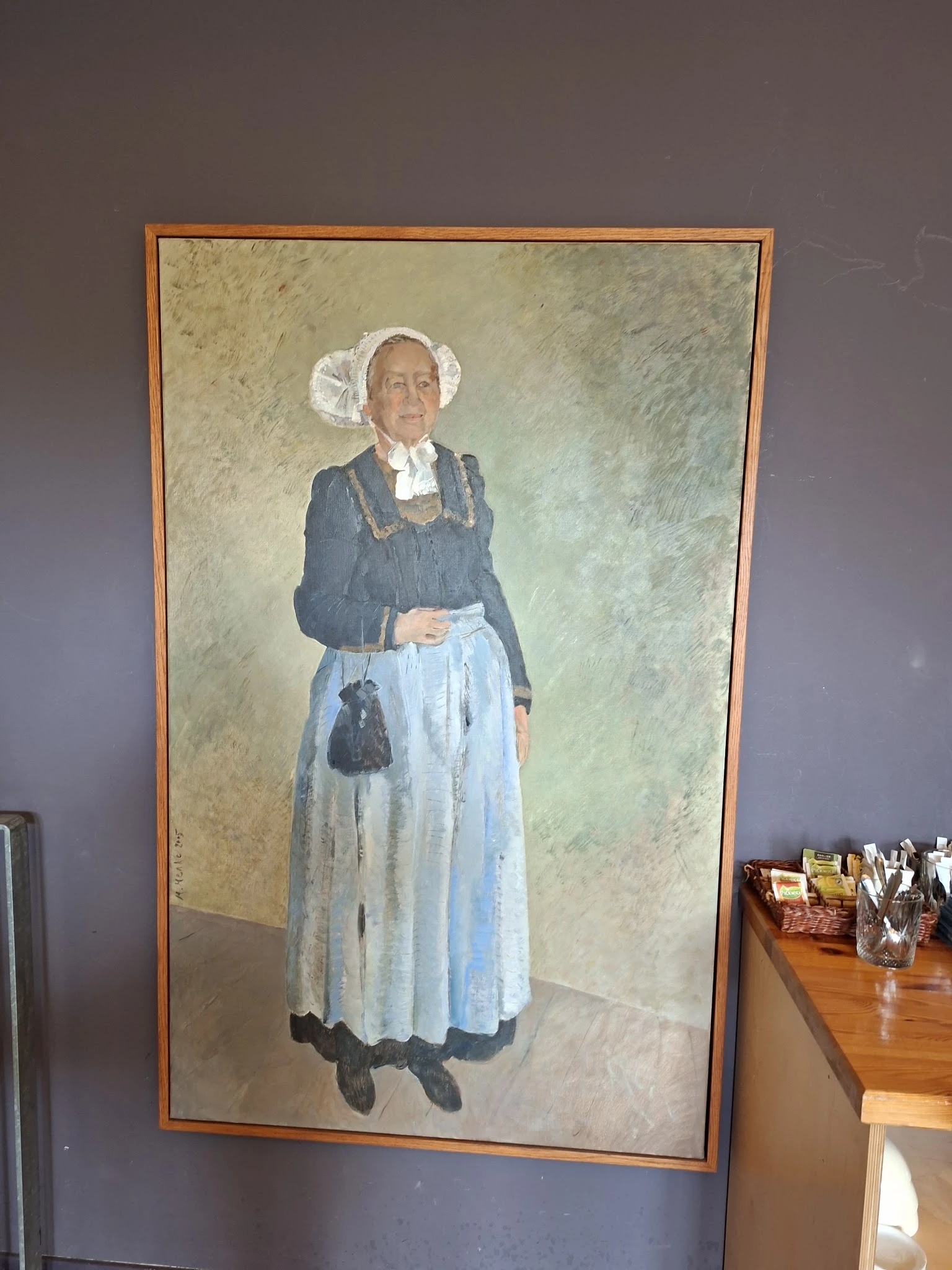 Schilderij van een oudere vrouw in traditionele klederdracht met witte kap en blauwe jurk