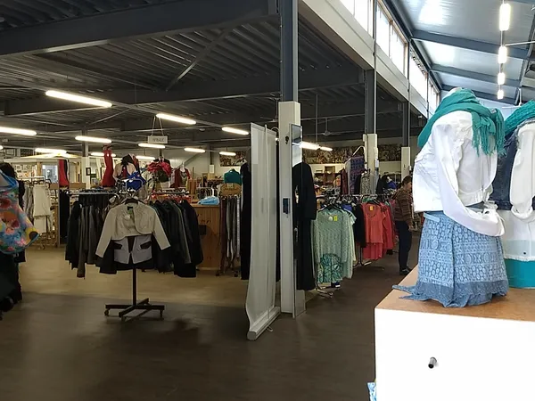 Winkelvloer met kledingrekken, toonpoppen en uitgestalde tweedehands kleding in een kringloopwinkel