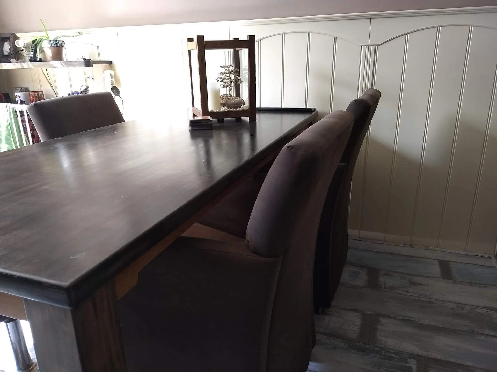 Zwarte houten tafel met bijpassende stoelen in een interieur met witte wanden