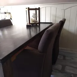 Zwarte houten tafel met bijpassende stoelen in een interieur met witte wanden
