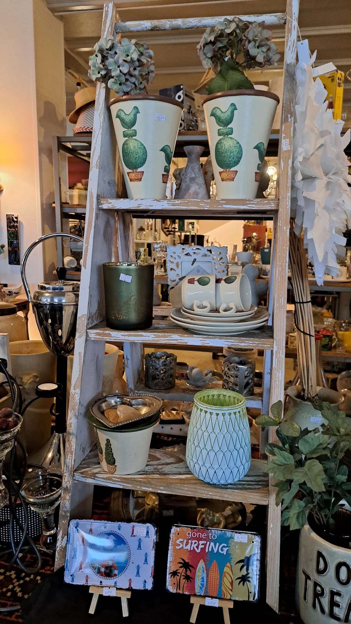 Vintage stellage met huishoudelijke artikelen: servies, kannen, kommen en decoratieve items