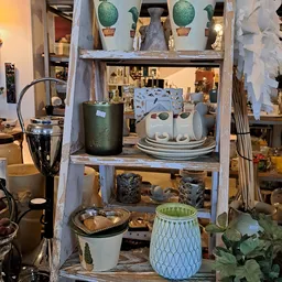 Vintage stellage met huishoudelijke artikelen: servies, kannen, kommen en decoratieve items