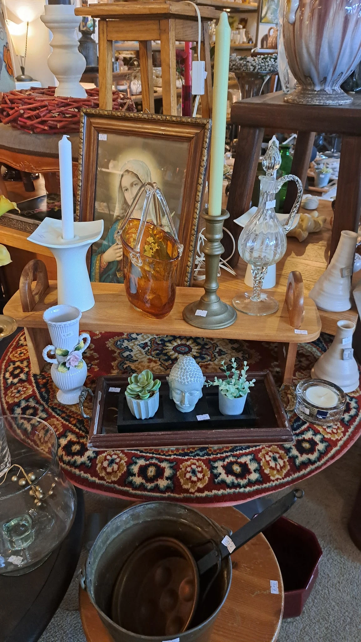 Vitrinekast met decoratieve objecten: witte vazen, plantjes in potten, en glazen items op zwarte achtergrond