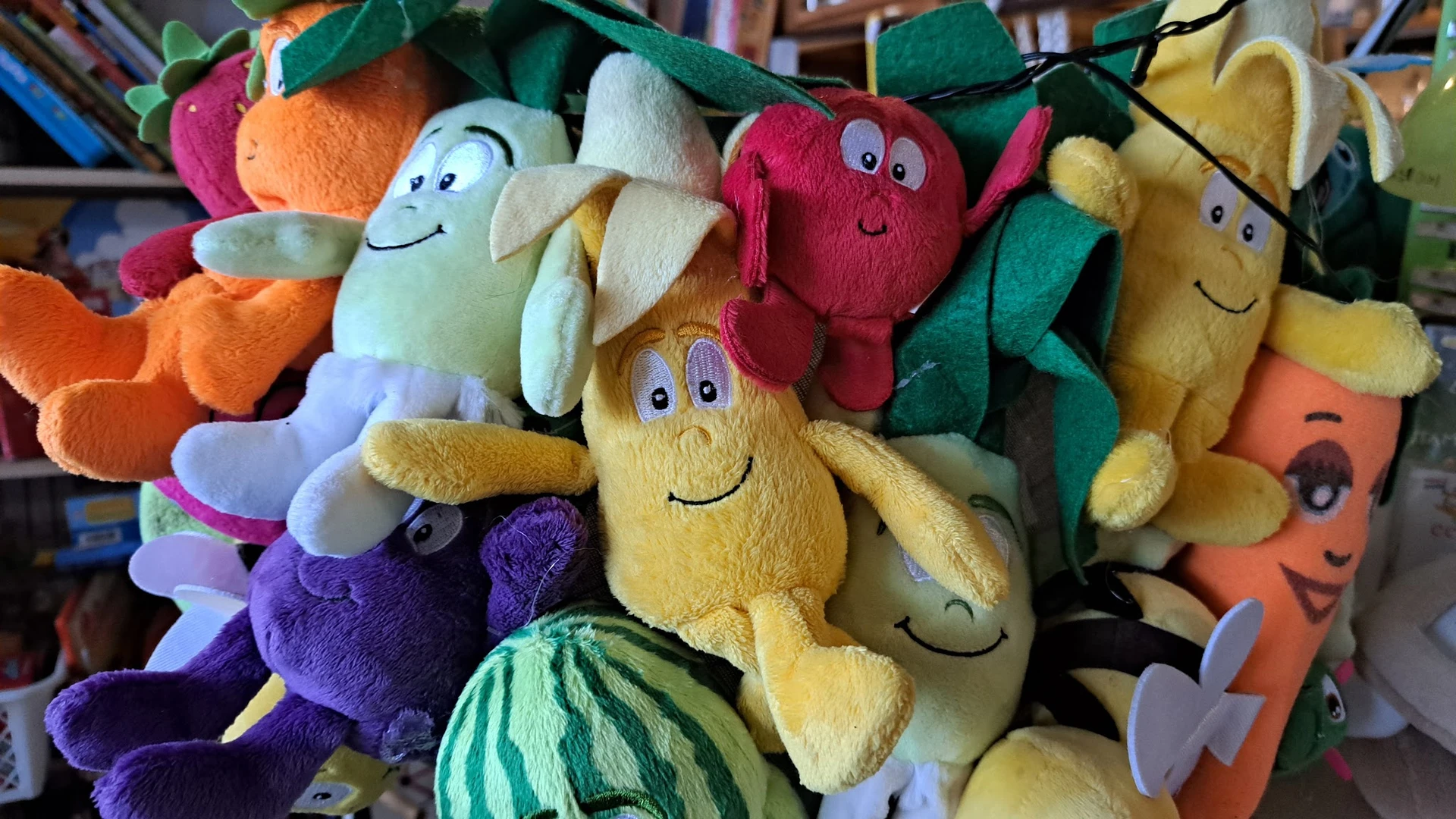 Stapel gekleurde pluche speelgoedfiguurtjes met smileysgezichten in verschillende kleuren
