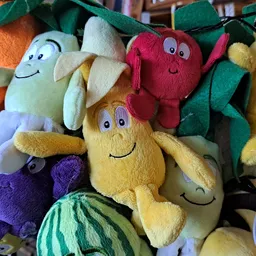 Stapel gekleurde pluche speelgoedfiguurtjes met smileysgezichten in verschillende kleuren