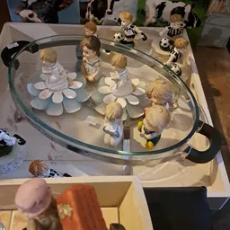 Glazen display met porseleinenen poppenhuispoppen en accessoires