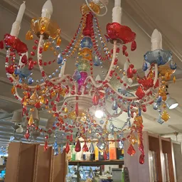 Kleurrijke decoratieve kroonluchter met rode, gele, blauwe en paarse kristallen en kralen aan hangers