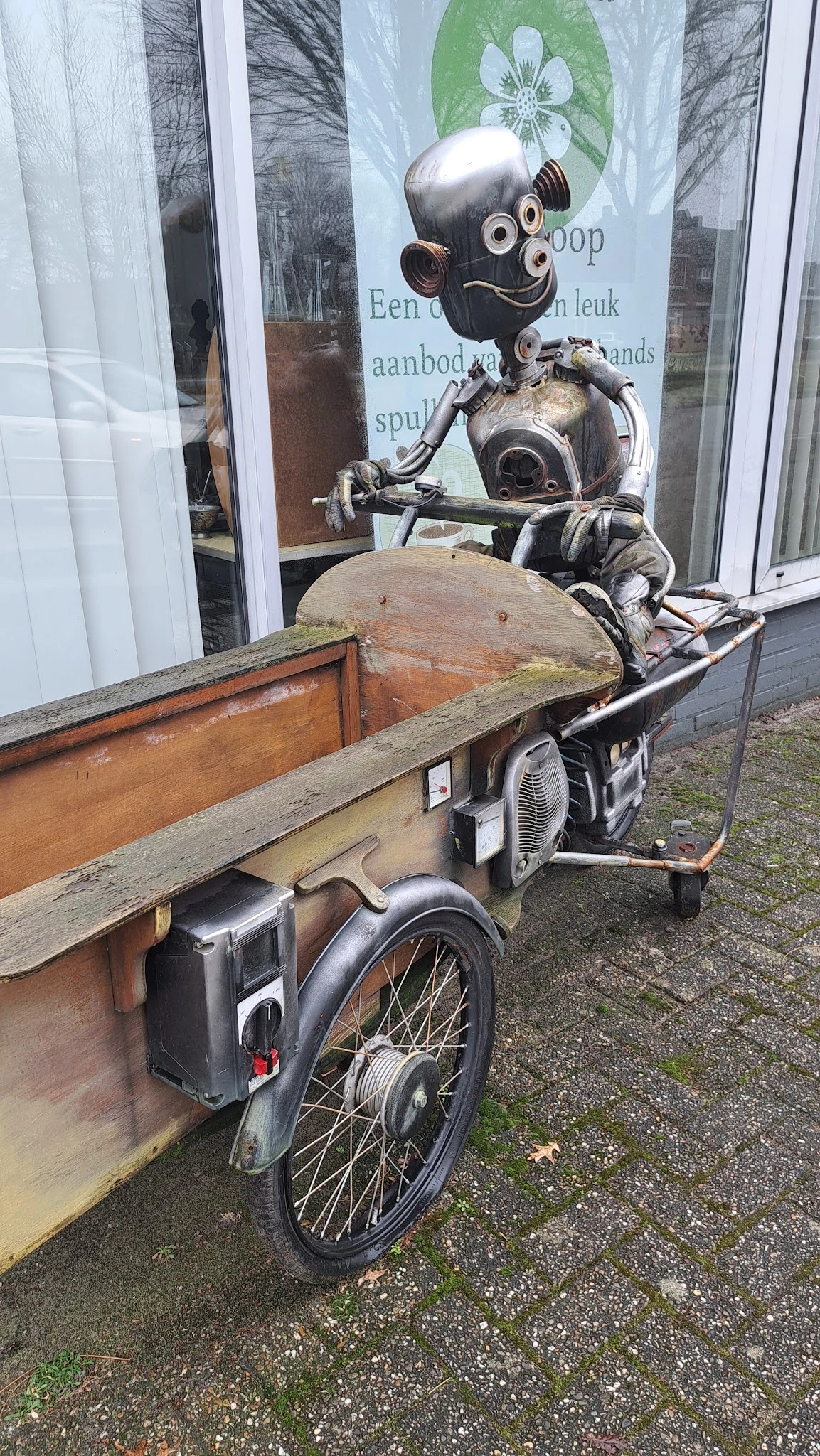 Tweedehands fietsen met zijspannen en houten aanhangwagen buiten de winkel