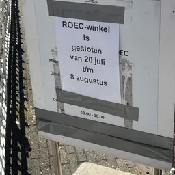 Wit papier met zwarte tekst: ROEC-winkel is gesloten van 20 juli t/m 8 augustus, 13.00 - 16.00
