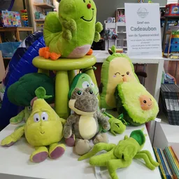 Uitstalling van pluche speelgoed in groene tinten: avocado's, peer, krokodil en vogels op een display