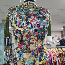 Mannequin bekleed met honderden gekleurde knoppen in diverse maten en kleuren