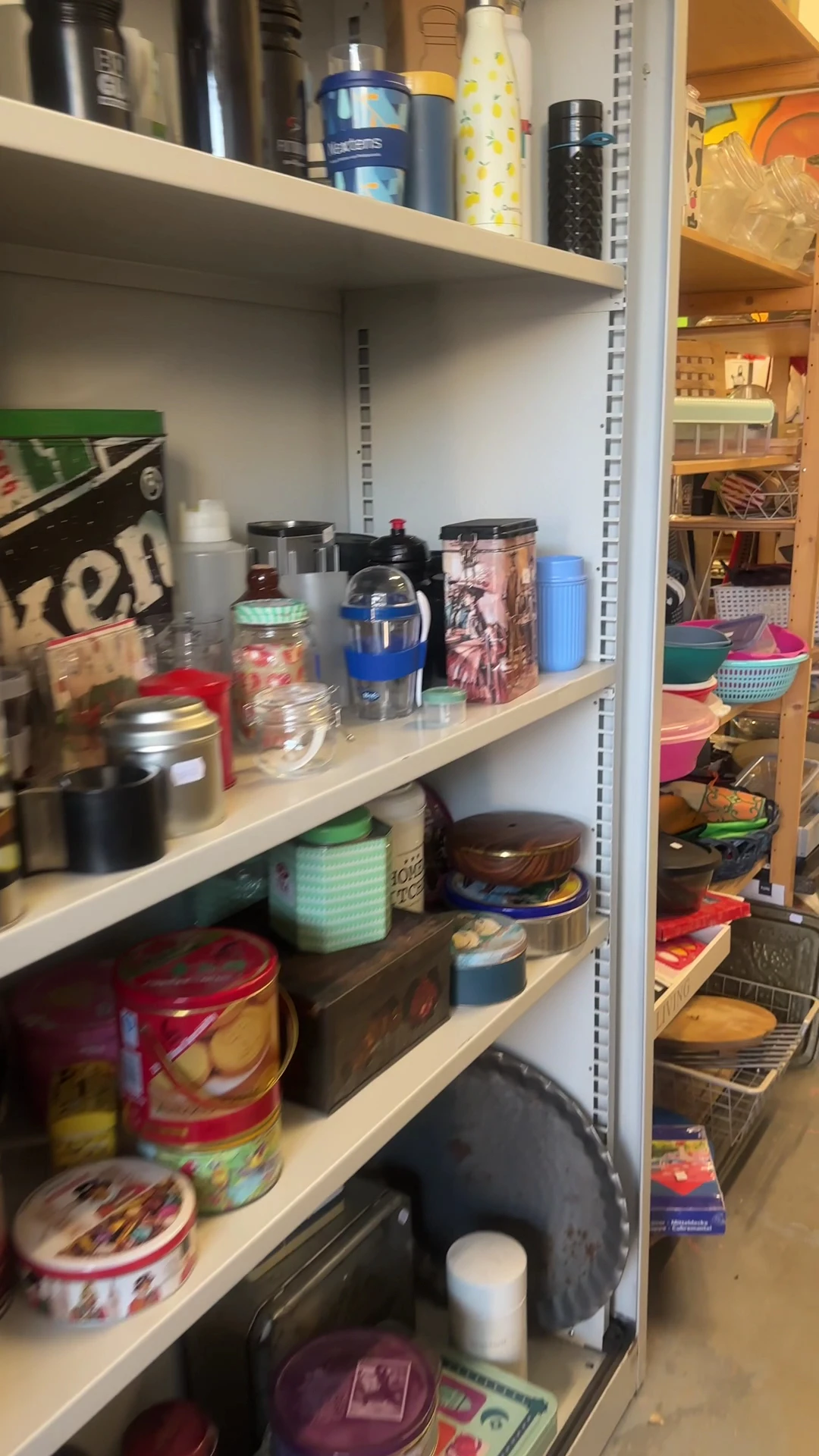 Stellingkast met diverse huishoudelijke artikelen zoals keukengerei, bewaardozen en keukenspullen