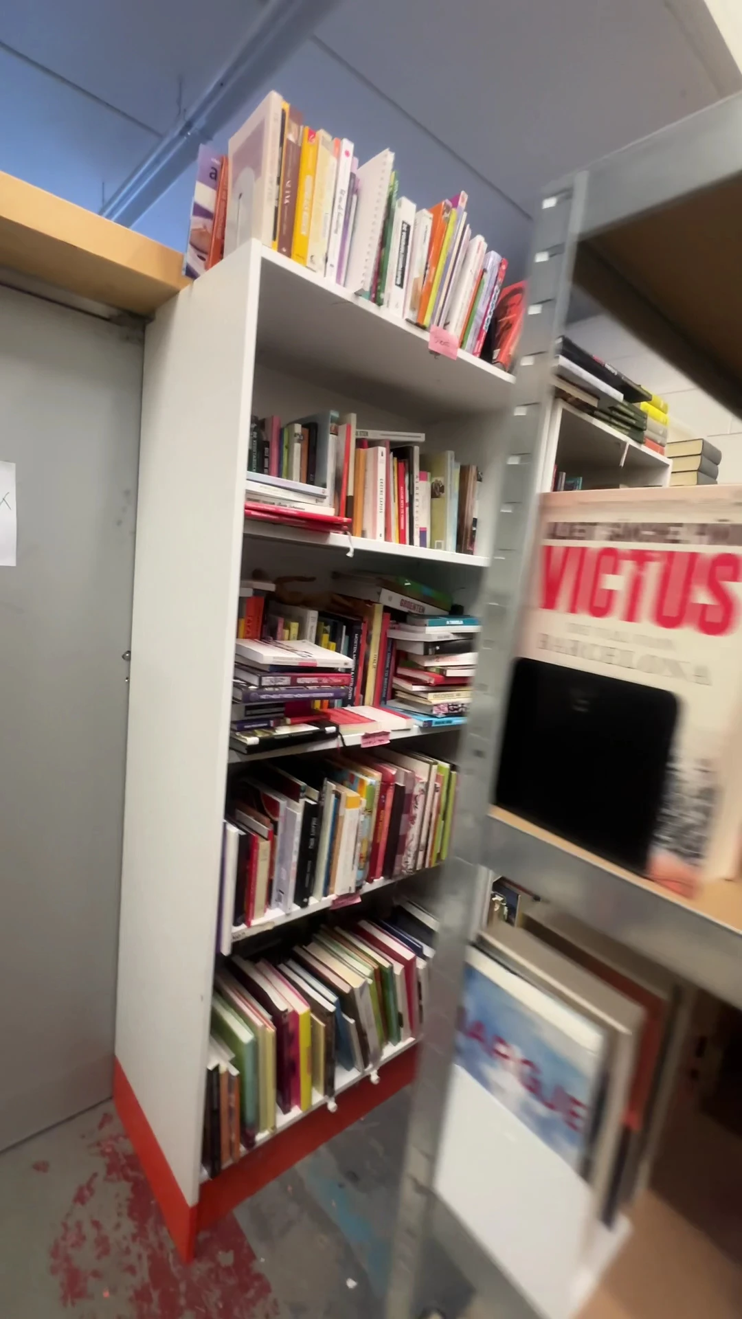 Boekenrek met tweedehands boeken, dvd's en ander media op meerdere planken