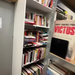 Boekenrek met tweedehands boeken, dvd's en ander media op meerdere planken