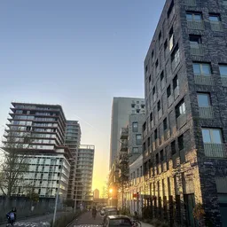Straatgezicht met moderne flatgebouwen bij zonsondergang