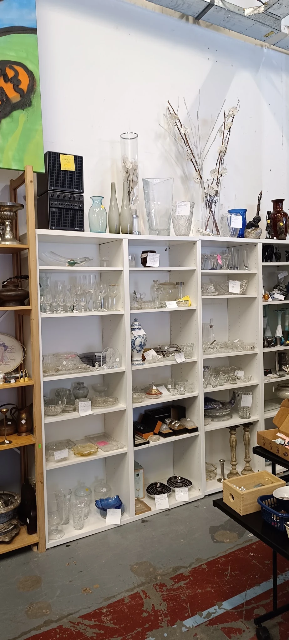 Witte open boekenkast vol met glazen en kristalglazen, diverse vormen en maten