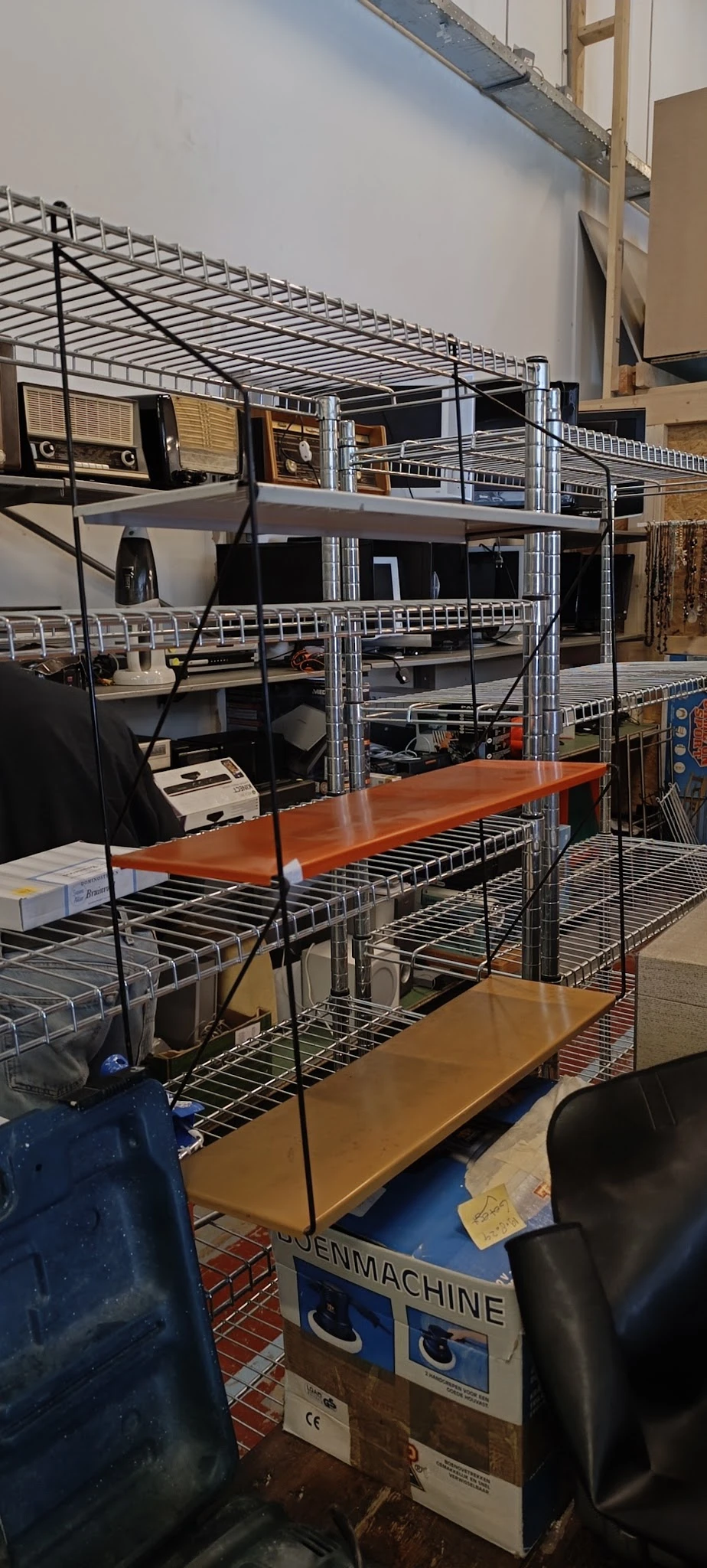 Metalen stellingen met houten werktafels en diverse kantoorapparatuur in de winkel