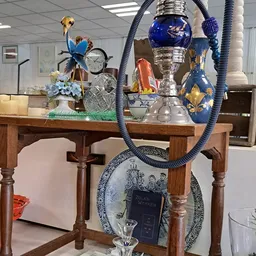 Houten tafel met diverse decoratieve artikelen zoals bloemen, trofeeën, borden en blauwe sierkandelaars
