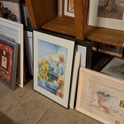 Ingelijste kunstwerken en schilderijen tegen elkaar in de winkel
