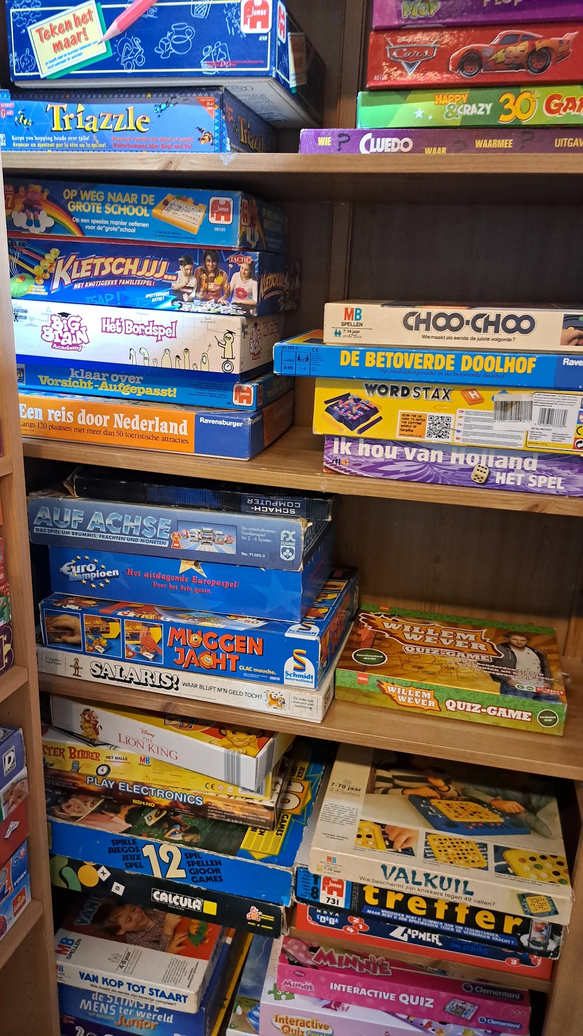 Stellage met stapels bordspellen en gezelschapsspellen, waaronder Choo-Choo, Wordstax en Moggenjacht