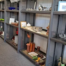 Vitrinekasten met uiteenlopend huishoudelijk en decoratief aanbod zoals serviesgoed, glazen, kaarsen en andere items