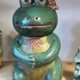 Groen geschilderd houten beeldje met gele buik, rode mond en rode strik, vintage decoratief object