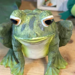 Groene decoratieve kikker met gele buik en oranje ogen
