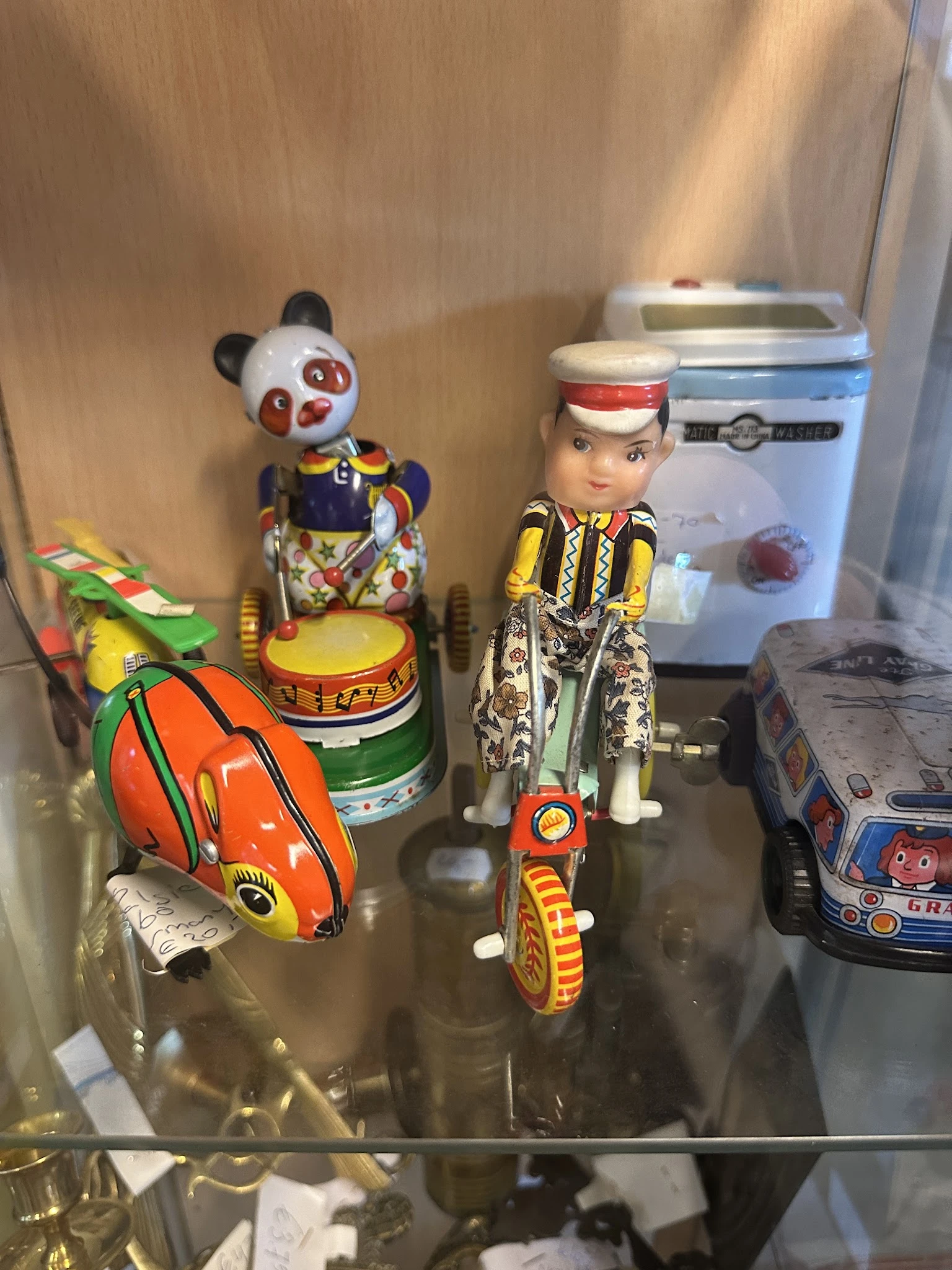 Vintage speelgoed en blikken voertuigen uitgestald op een plank in de winkel