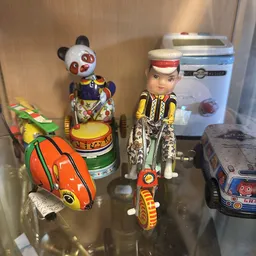 Vintage speelgoed en blikken voertuigen uitgestald op een plank in de winkel