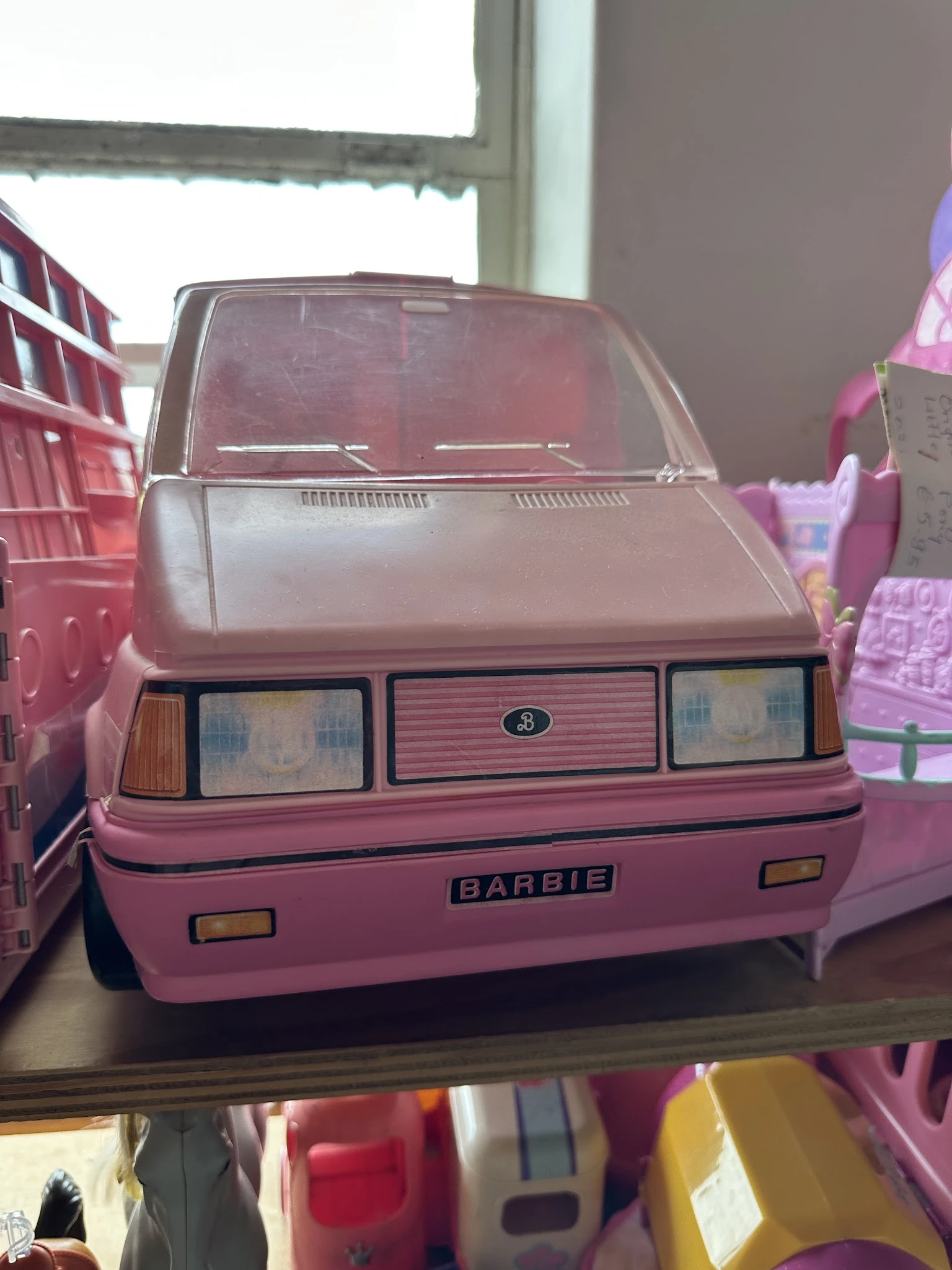 Roze Barbie-auto met open deuren in een kringloopwinkel