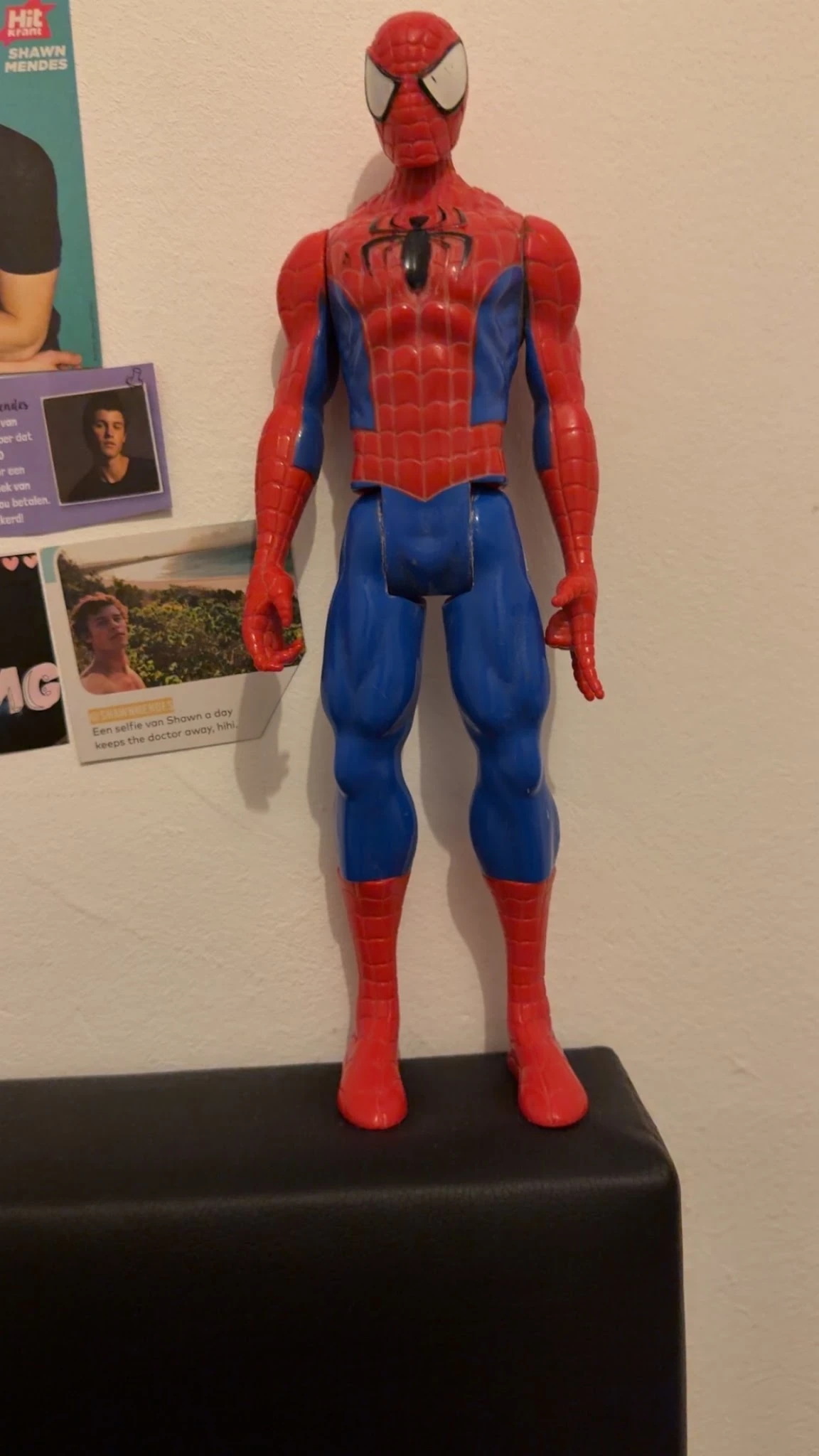 Spiderman actiefiguur met rood en blauw kostuum tegen witte muur