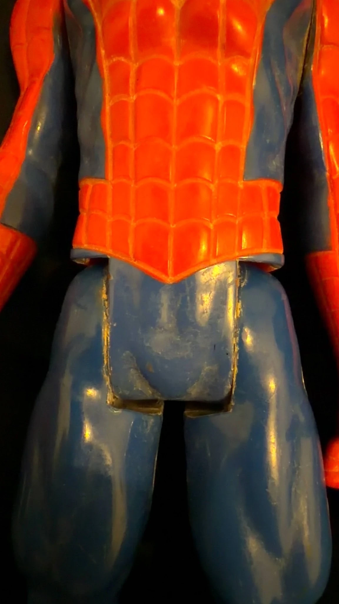 Close-up van een rood en blauwe kunststof speelgoedfiguur met gouden details