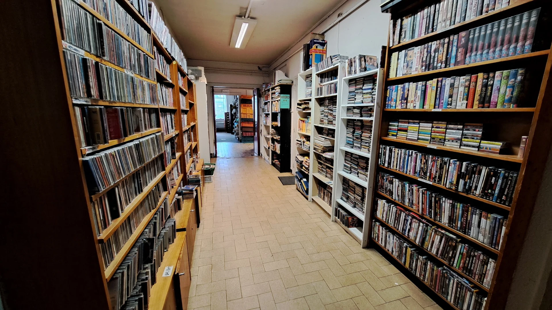 Winkelruimte met kasten vol CD's en dvd's langs beide zijden van het gangpad