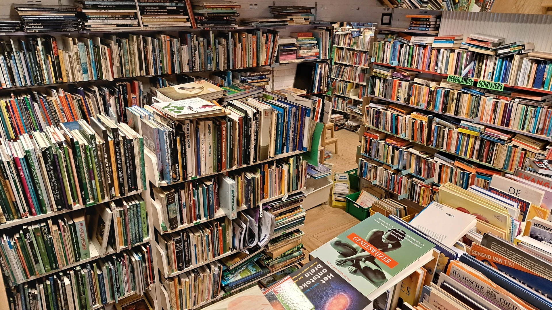 Rekken en stellingen vol met tweedehands cd's, dvd's en boeken in kringloopwinkel