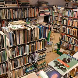 Rekken en stellingen vol met tweedehands cd's, dvd's en boeken in kringloopwinkel