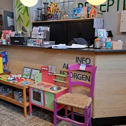 Winkelvloer met kindermeubels, speelgoed en infokaarten achter de toonbank