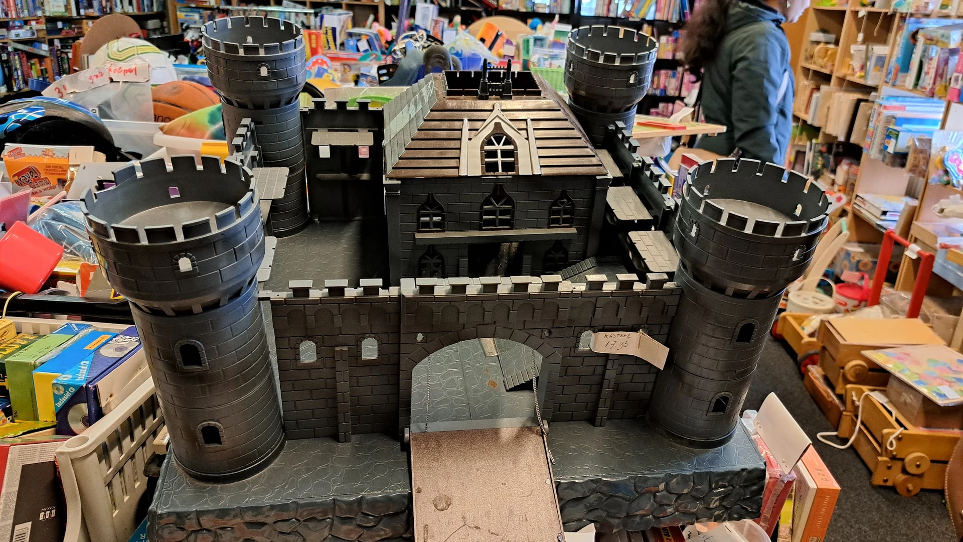 Groot zwart speelgoedkasteel met torens, poorten en details, tentoongesteld in de winkel