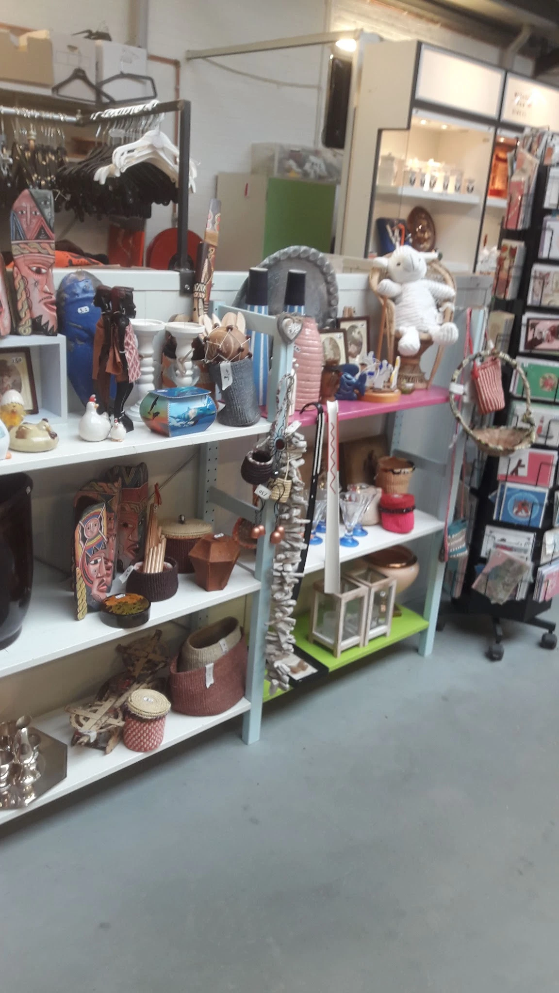 Stellingen met diverse tweedehands items zoals decoraties, servies, boeken en souvenirs